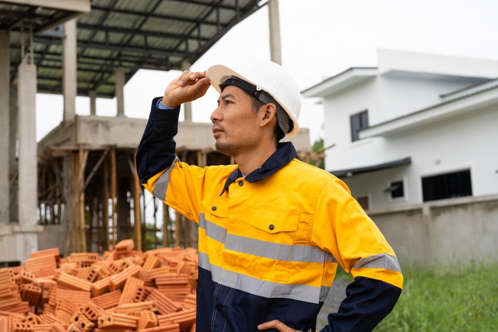 Contractor supervising construction workers on a residential site.